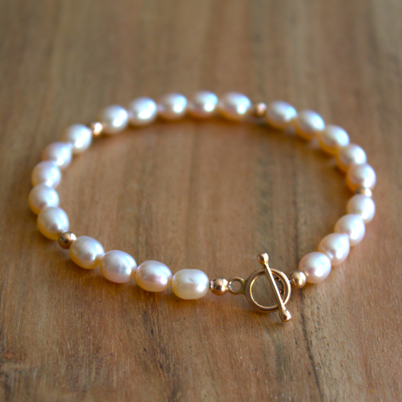 Gouden armband met zachte roze zoetwaterparels afgewisseld met gouden balletjes. Stoer en vrouwelijk met een sierlijke kapittelsluiting. Handgemaakt door Goudsmederij Goedbloed