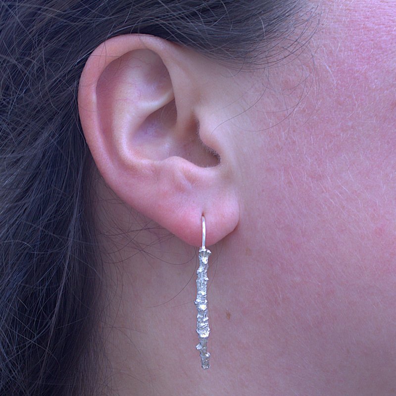 Zilveren lange oorhaken van een zilveren eiken tak organisch en natuurlijk ontwerp ambachtelijk en met de hand gemaakt door Goudsmederij Goedbloed foto op model