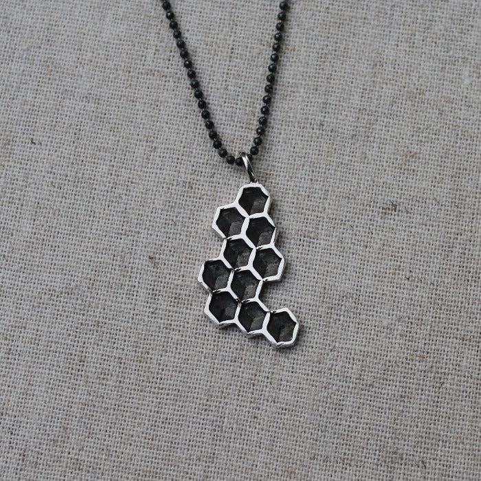 925 Zilveren Honey hanger. Een hanger met de geometrische schoonheid van honingraat. Handgemaakt door Goudsmederij Goedbloed.