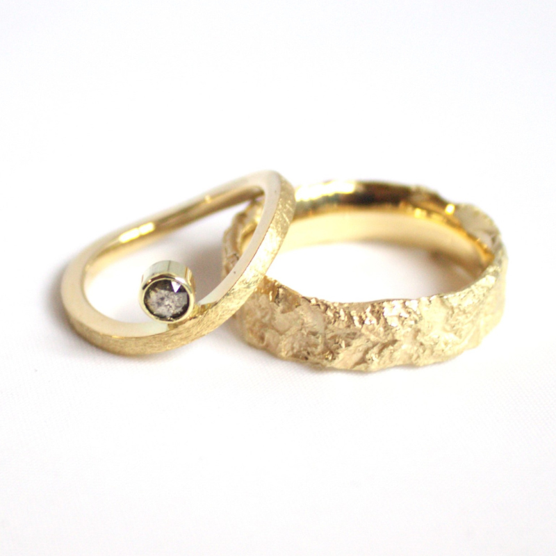 Eigentijds design 14 karaat gouden ring met een golvende ijs gematteerde band en een roosgeslepen zout en peper diamant gezet in een strakke gesloten kast handgemaakt door Goudsmederij Goedbloed 