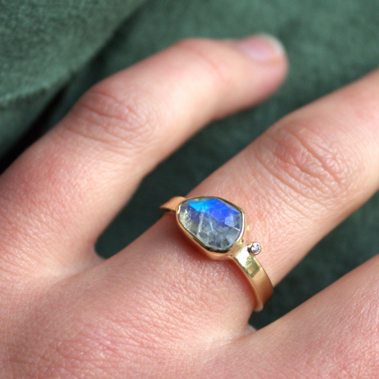 Unieke 14 karaat geelgouden ring met een fantasie geslepen regenboog maansteen en een fijne witte diamant handgemaakt door Goudsmederij Goedbloed