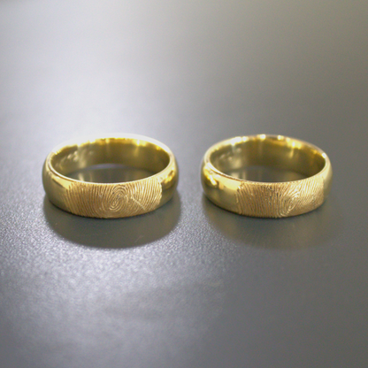 Klassieke gouden trouwringen met vingerafdruk lasergravure, ook mogelijk aan de binnenzijde van de ring. handgemaakt door Goudsmederij Goedbloed