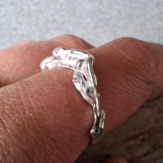 Een van zilver gevormd elvenbankje dat speels over de vinger golft als vloeibaar lava. Handgemaakt en duurzaam ontwerp door Goudsmederij Goedbloed