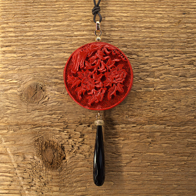 Een unieke hanger met een tablet van Chinese rode gom welke gegraveerd is met een prachtige bloempatroon en als afsluiter een facetgeslepen zwarte onyx welke gevat is in een eikenkap van goud. Uniek en handgemaakt door Goudsmederij Goedbloed