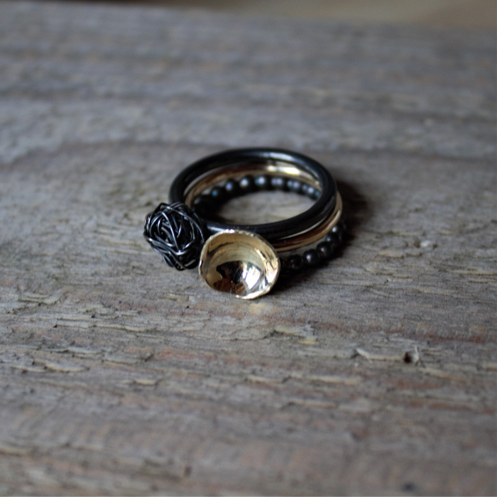 Geelgouden ring met hoogglans gepolijst kommetje met 2 zwart zilveren aanschuifringen handgemaakt door Goudsmederij Goedbloed